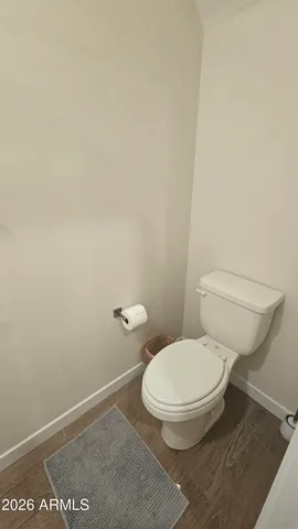 a white toilet sitting next to a white wall