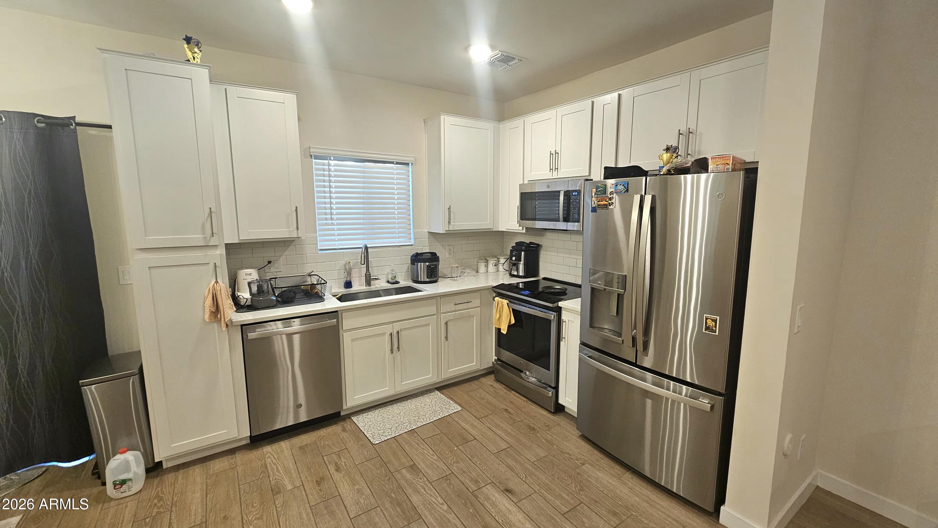2818 West Red Fox Road Phoenix, AZ 85085 - Photo 2 of 19 a kitchen with stainless steel appliances a refrigerator sink and microwave