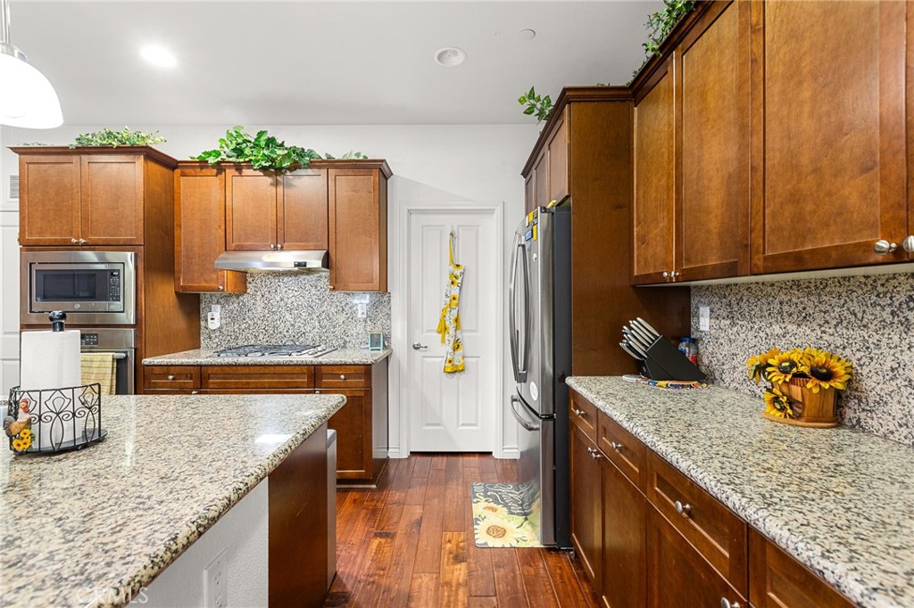 1575 North Grove Street Redlands, CA 92374 - Photo 11 of 45 a kitchen with stainless steel appliances granite countertop a sink a stove and a wooden cabinets