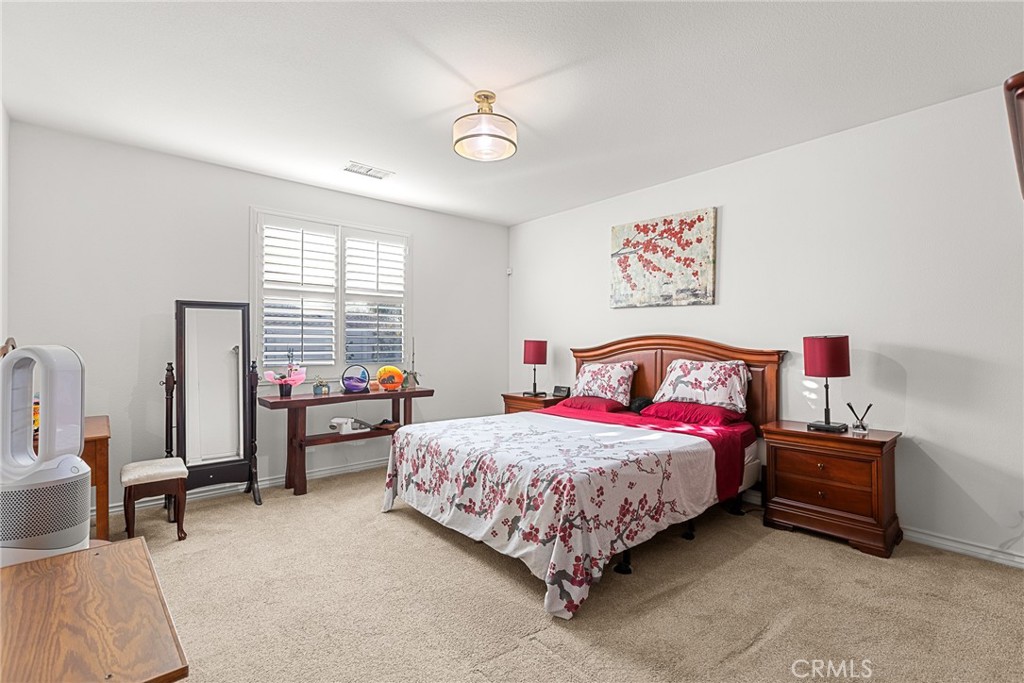 1575 North Grove Street Redlands, CA 92374 - Photo 18 of 45 a bedroom with a bed and a chandelier