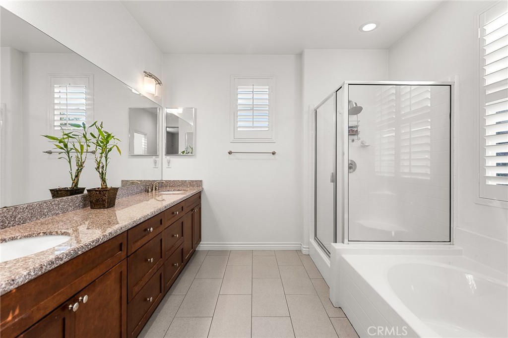 1575 North Grove Street Redlands, CA 92374 - Photo 20 of 45 a bathroom with a granite countertop sink a mirror a bathtub and next to a window