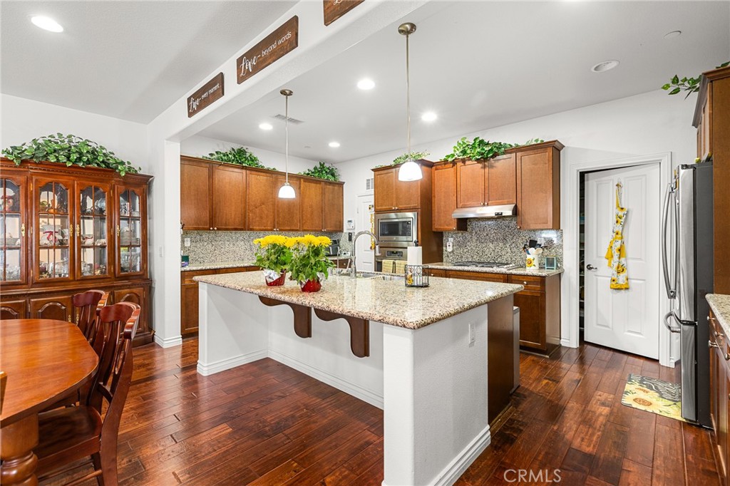 1575 North Grove Street Redlands, CA 92374 - Photo 10 of 45 a kitchen with stainless steel appliances granite countertop a refrigerator a sink dishwasher a stove and white cabinets with wooden floor