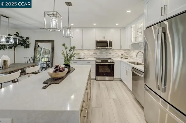 a kitchen with stainless steel appliances a stove a refrigerator and a sink
