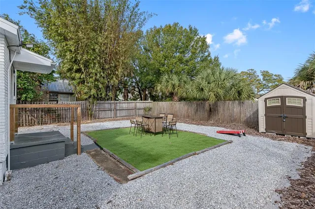 a view of backyard with wooden fence and a slide