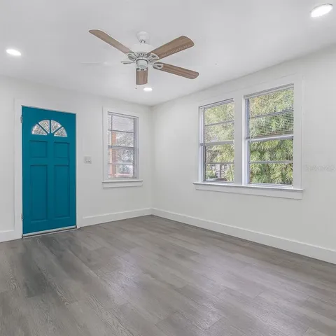 a view of an empty room with a window and a ceiling fan