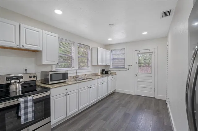 a kitchen with white cabinets and white appliances
