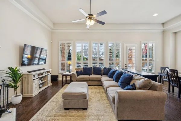a living room with furniture flat screen tv and a large window