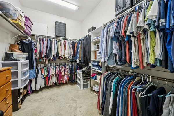 a view of walk in closet with clothes and shoes