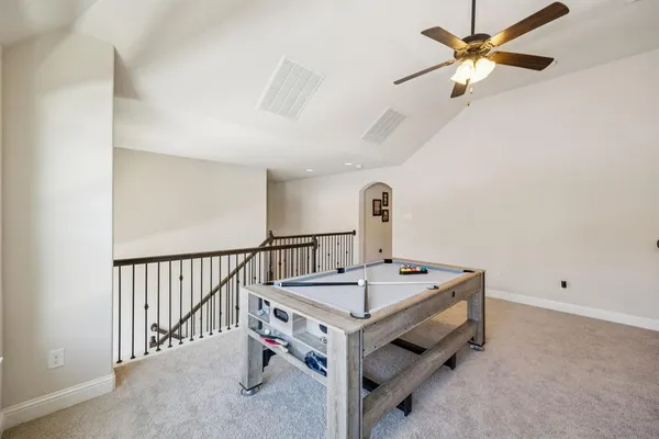 a room with pool table and ceiling fan