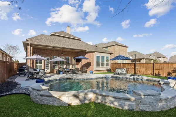 a view of a big house with swimming pool and sitting area