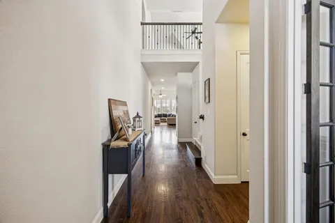 a view of a hallway with wooden floor and staircase