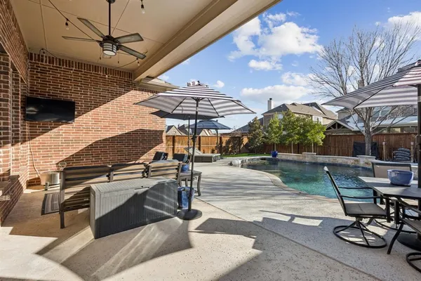 a view of a patio with a table and chairs under an umbrella
