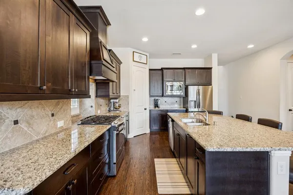a kitchen with granite countertop stainless steel appliances and wooden cabinets