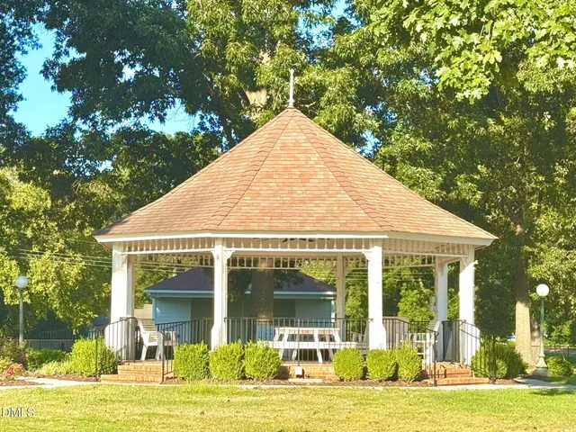 a view of entrance gate of a house with garden and trees