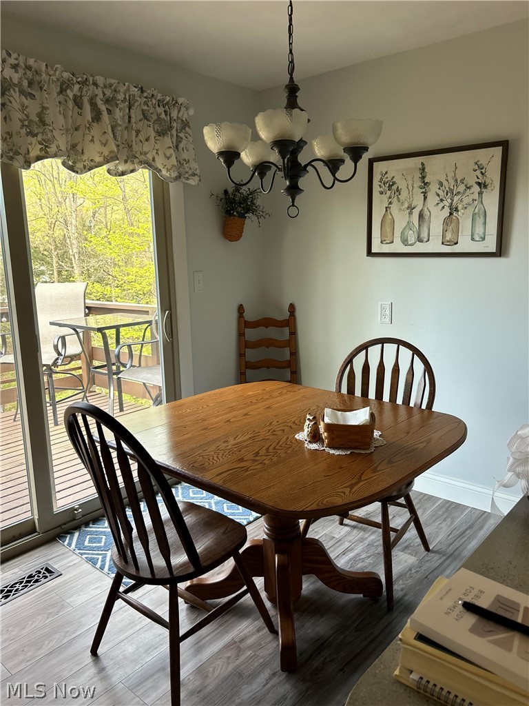 8871 Clinton Road Cambridge, OH 43725 - Photo 14 of 33 Dining area with dark hardwood / wood-style floors and a notable chandelier