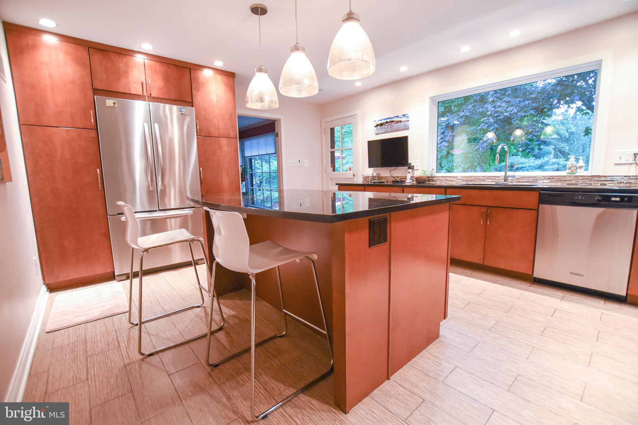 1227 Pinewood Road Villanova, PA 19085 - Photo 12 of 43 a kitchen with stainless steel appliances granite countertop a table chairs in it and wooden floors