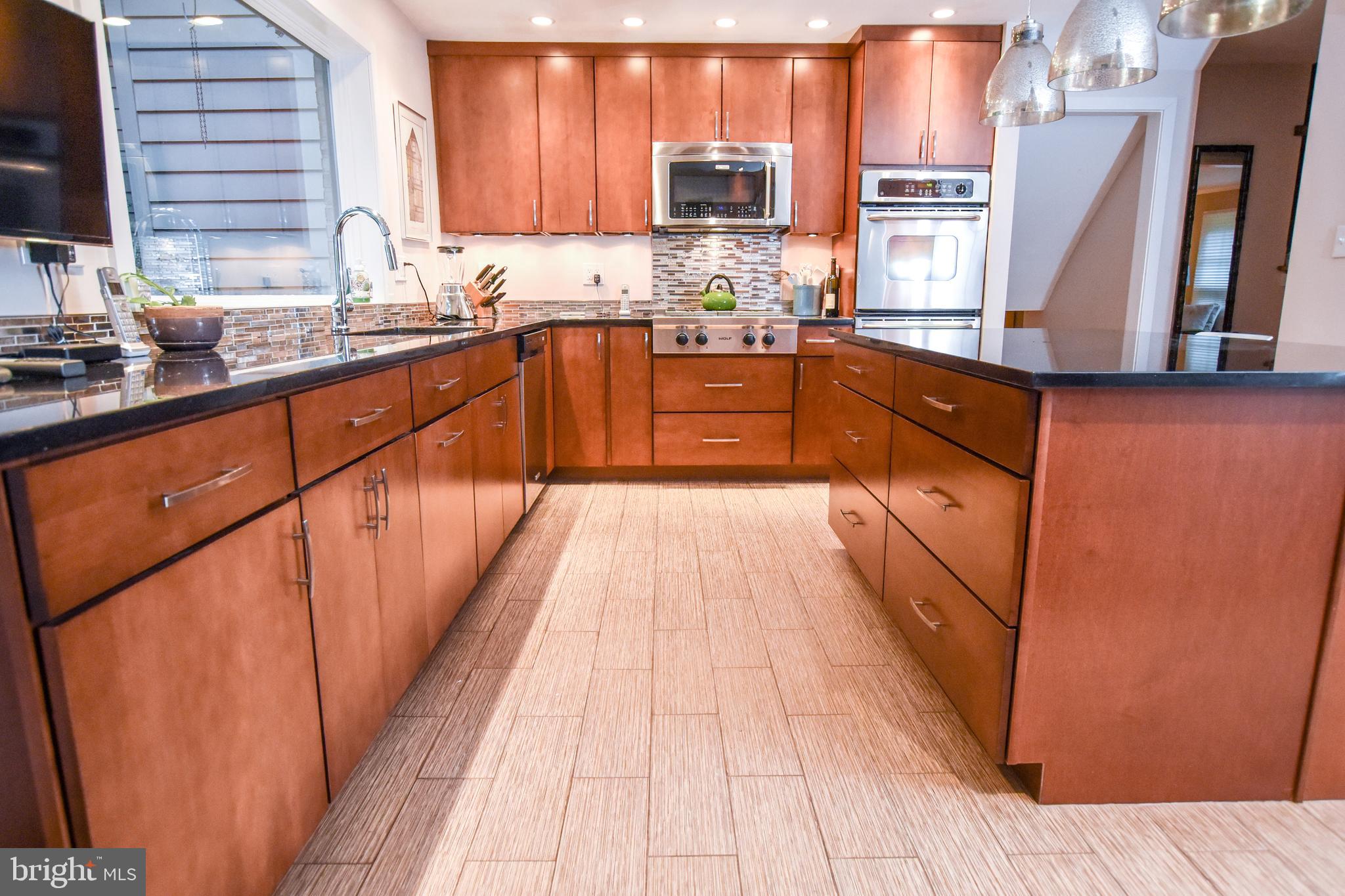 1227 Pinewood Road Villanova, PA 19085 - Photo 13 of 43 a large kitchen with granite countertop a sink dishwasher stove and cabinets