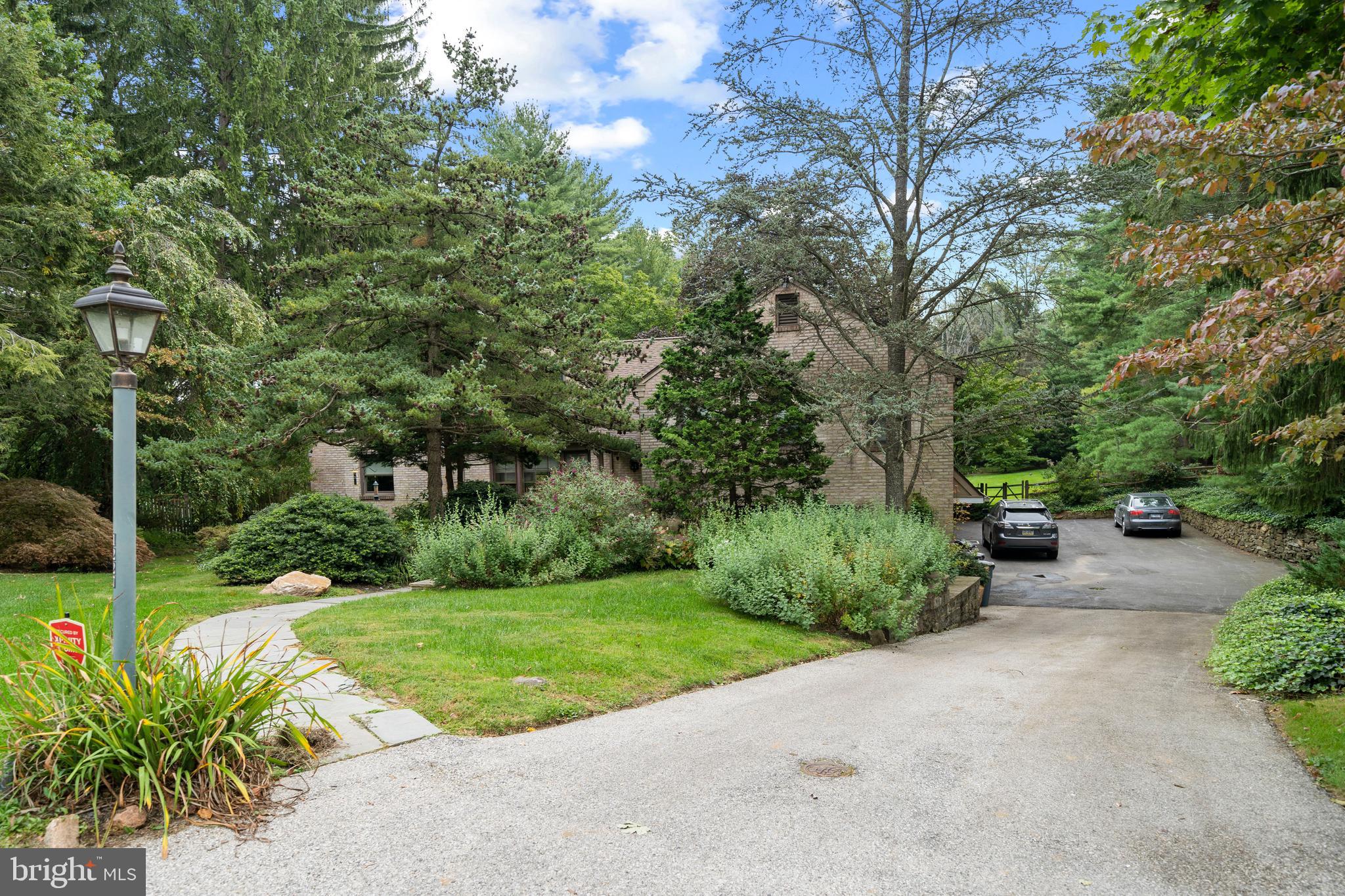 1227 Pinewood Road Villanova, PA 19085 - Photo 6 of 43 a view of a garden with potted plants and large trees