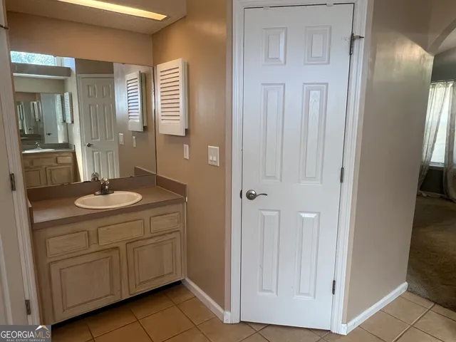 a bathroom with a granite countertop sink a mirror and a shower