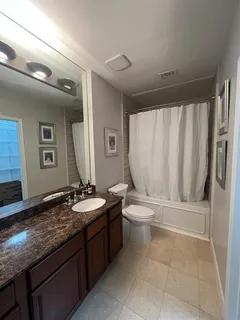 a bathroom with a granite countertop sink toilet and shower