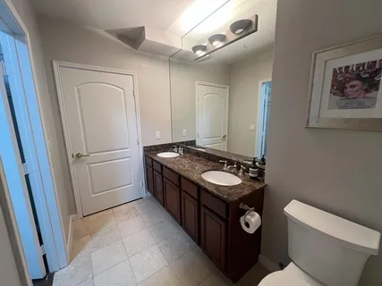 a bathroom with a sink a toilet a mirror and shower