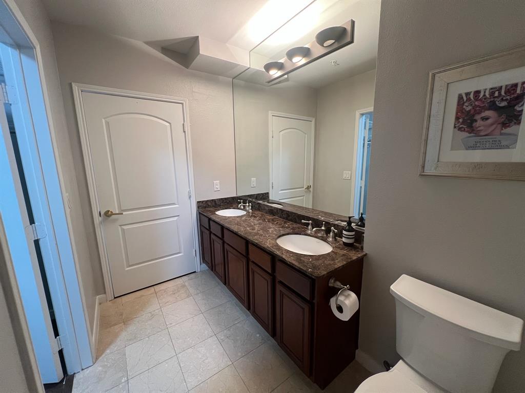 3225 Turtle Creek Boulevard, Unit 1706 Dallas, TX 75219 - Photo 7 of 13 a bathroom with a sink a toilet a mirror and shower
