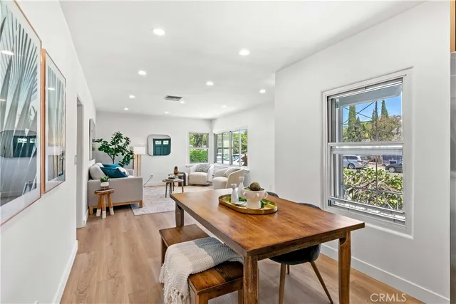 a kitchen with stainless steel appliances refrigerator dining table and chairs
