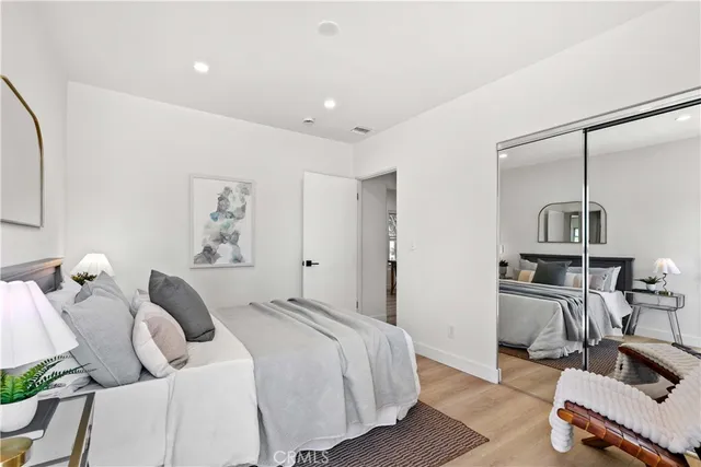 a bedroom with a bed and wooden floor