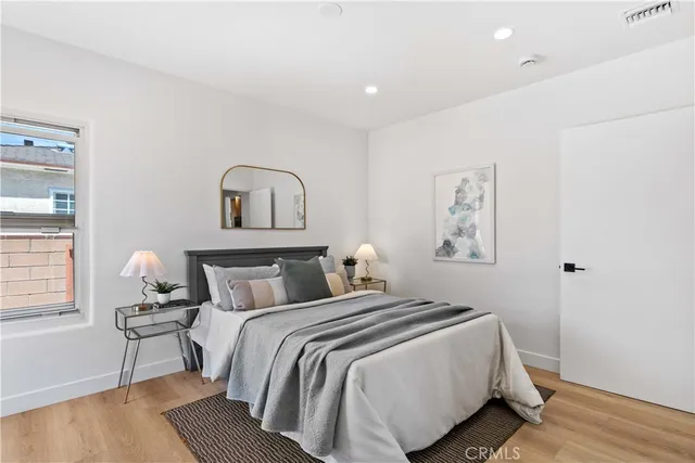 a bedroom with a bed and wooden floor