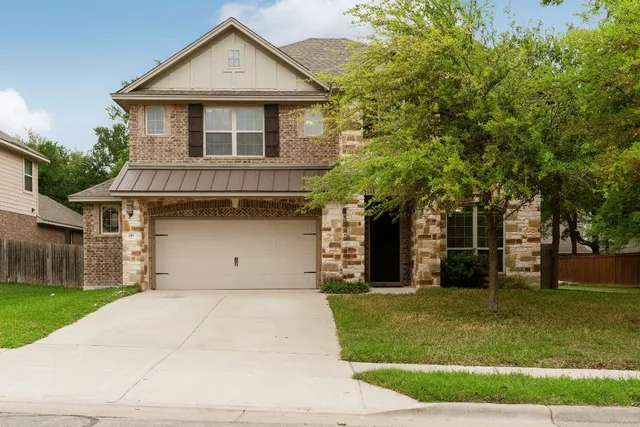 a front view of a house with a yard and trees