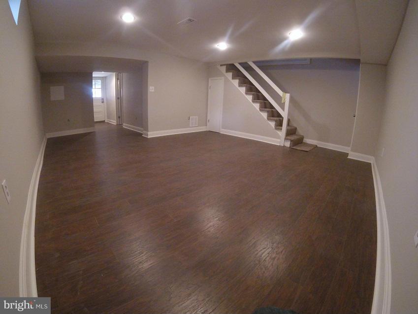 1317 Silverthorne Road Baltimore, MD 21239 - Photo 22 of 25 an empty room with wooden floor and windows