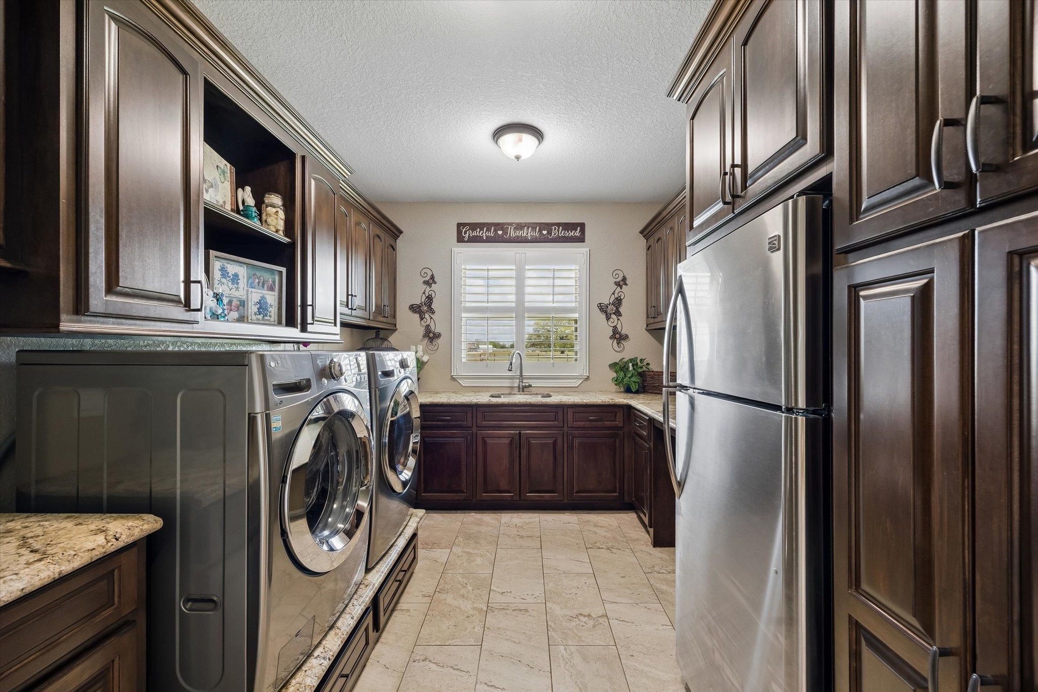 17703 Cedarhill Drive Rosharon, TX 77583 - Photo 14 of 47 The laundry room redefines functional luxury — floor-to-ceiling custom cabinetry, granite countertops, a utility sink, plantation shutters, and room for a second refrigerator make this one of the most impressive utility spaces you'll find in any home.