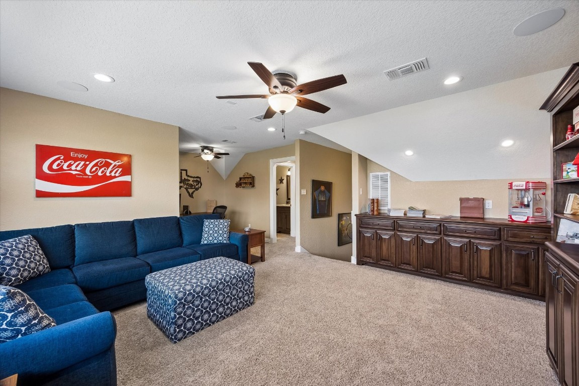 17703 Cedarhill Drive Rosharon, TX 77583 - Photo 24 of 47 The upstairs media and game room offers the ultimate retreat for movie nights and entertaining, complete with built-in custom cabinetry, plush carpet, recessed lighting, ceiling fan, and windows overlooking the peaceful neighborhood.