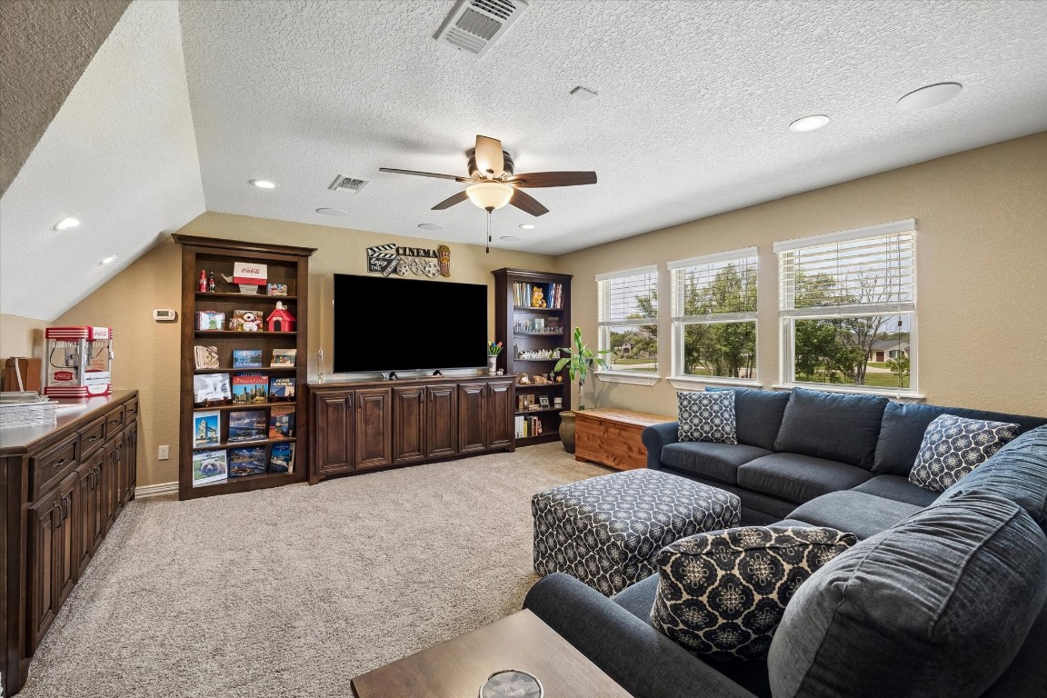 17703 Cedarhill Drive Rosharon, TX 77583 - Photo 25 of 47 The generous upstairs game room offers abundant space for a second living area, playroom, or entertainment lounge, with custom built-in cabinetry, dual ceiling fans, recessed lighting, and easy access to the hidden room beyond.