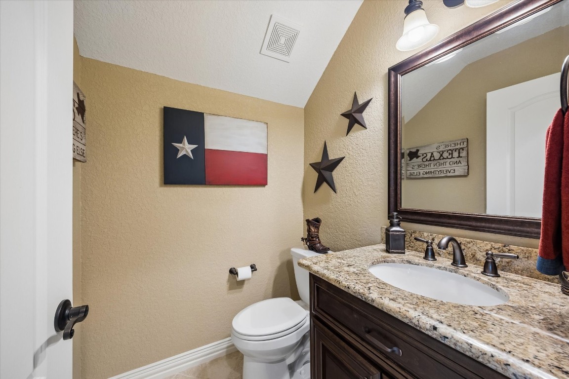 17703 Cedarhill Drive Rosharon, TX 77583 - Photo 27 of 47 A charming and functional half bath featuring granite countertops, a dark custom vanity, and oil-rubbed bronze fixtures — perfectly appointed and consistent with the quality finishes found throughout this one-of-a-kind home.