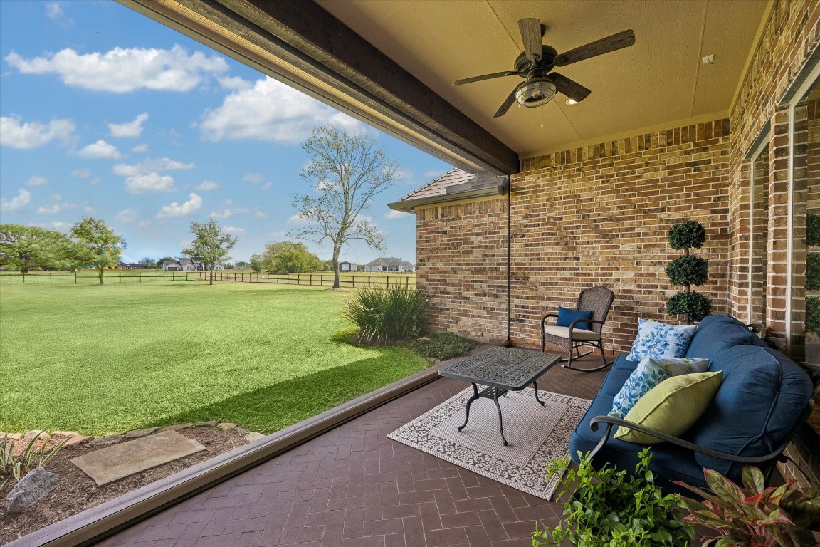 17703 Cedarhill Drive Rosharon, TX 77583 - Photo 30 of 47 Step directly from the dining room onto this charming private patio, complete with a ceiling fan and motorized electric shade — creating a comfortable, all-season outdoor dining and lounging experience no matter the Texas weather.