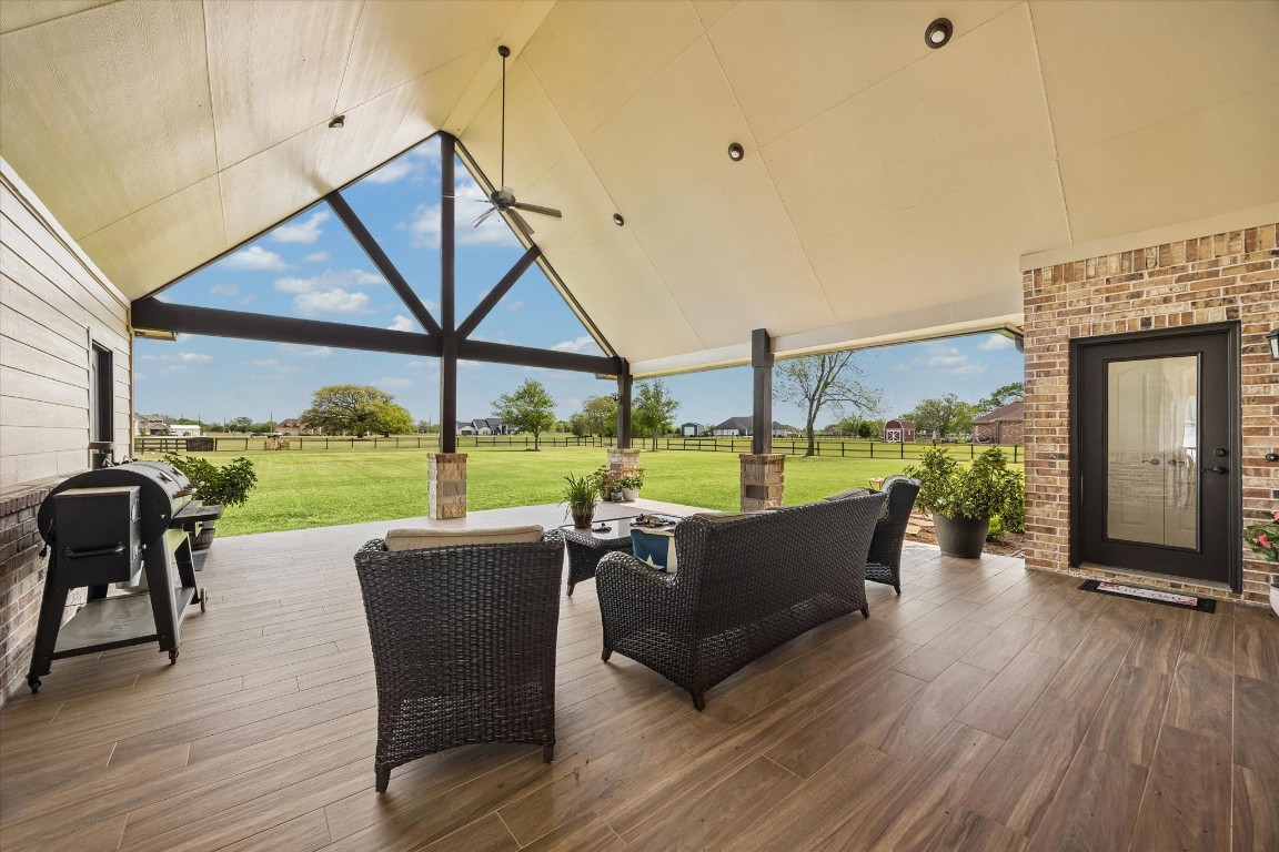 17703 Cedarhill Drive Rosharon, TX 77583 - Photo 31 of 47 The spectacular extended covered patio is an entertainer's dream, featuring soaring vaulted ceilings with dramatic exposed beam trusswork, wood-look tile flooring, ceiling fan, recessed lighting, and sweeping open acreage views — an outdoor living room unlike any other.