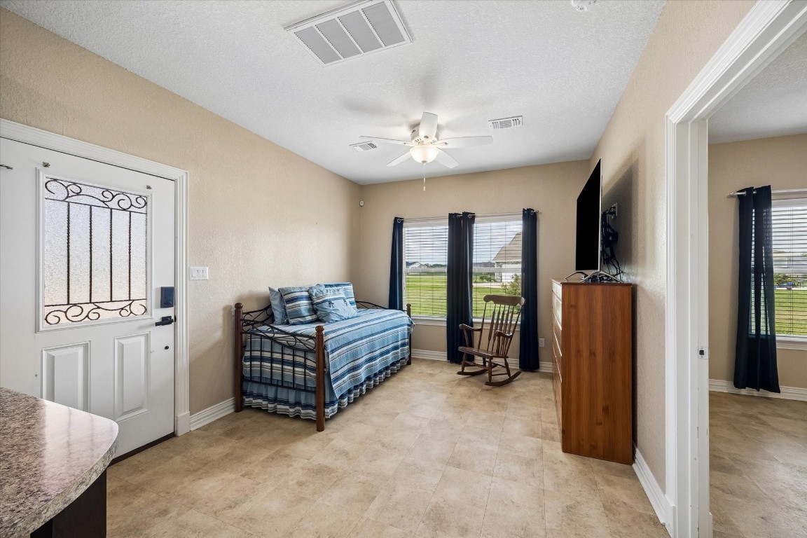 17703 Cedarhill Drive Rosharon, TX 77583 - Photo 34 of 47 The detached casita welcomes guests with a bright and comfortable living area featuring a private iron-glass entry door, ceiling fan, and windows with peaceful neighborhood views — a completely self-contained space that lives like a true home away from home.