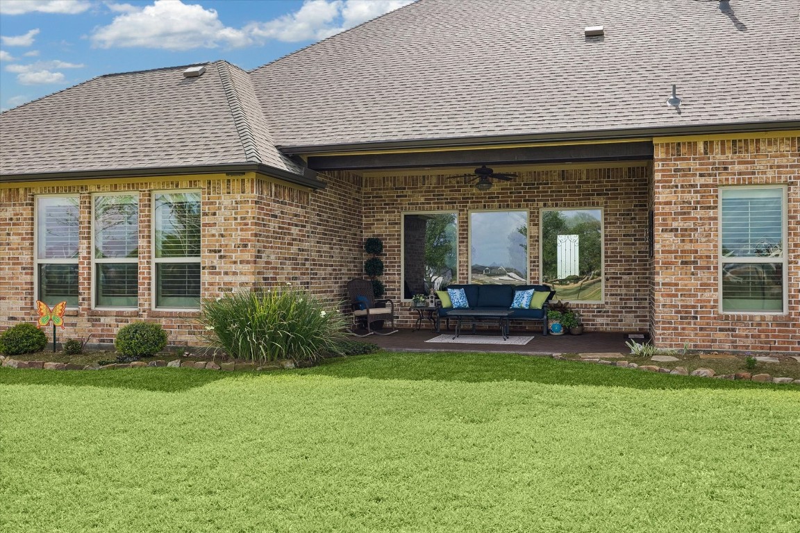 17703 Cedarhill Drive Rosharon, TX 77583 - Photo 39 of 47 A charming covered patio off the main living area features a ceiling fan and motorized electric shade — creating a private, comfortable outdoor retreat perfectly suited for morning coffee, evening relaxation, or simply soaking in the peaceful acreage views year-round.