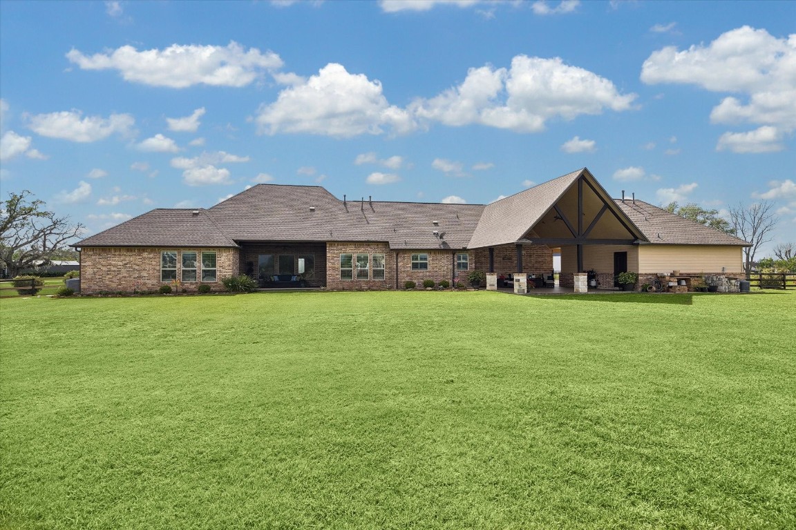 17703 Cedarhill Drive Rosharon, TX 77583 - Photo 41 of 47 The impressive rear elevation showcases the full breadth of this custom home, with the dramatic vaulted covered patio anchoring the right side and a wall of windows across the back inviting natural light deep into the living spaces.