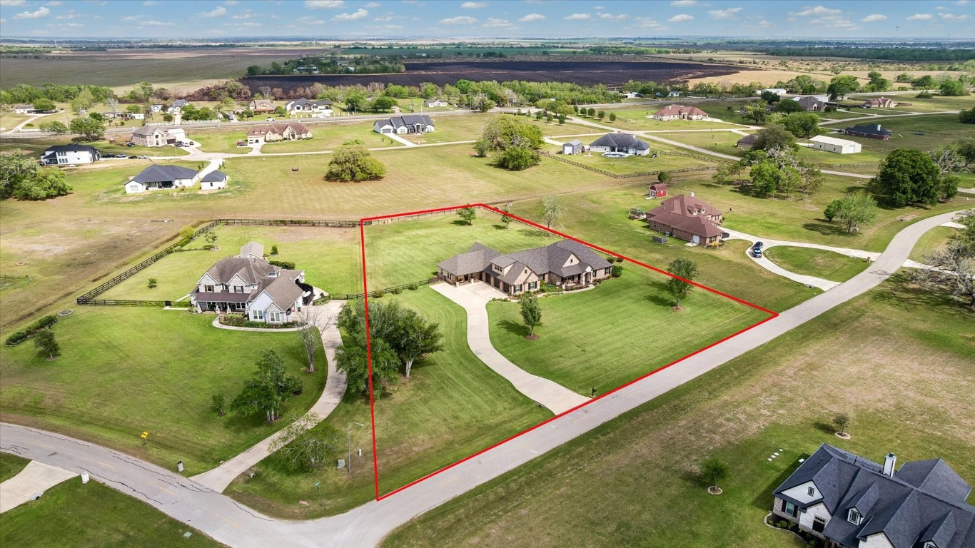 17703 Cedarhill Drive Rosharon, TX 77583 - Photo 5 of 47 A stunning bird's-eye view reveals the full scope of this exceptional 2-acre property — showcasing the sweeping driveway, the main home, detached casita, expansive covered patio, and generous lot boundaries set among Suncreek Estates' most coveted acreage homesites.