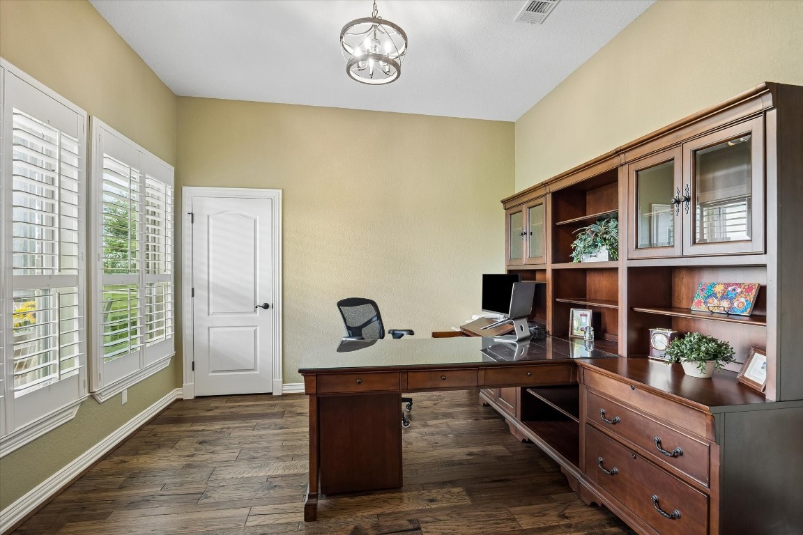 17703 Cedarhill Drive Rosharon, TX 77583 - Photo 7 of 47 A dedicated private home office with gorgeous hardwood floors, plantation shutters, and a statement chandelier creates the ideal work-from-home sanctuary — quiet, functional, and beautifully appointed.