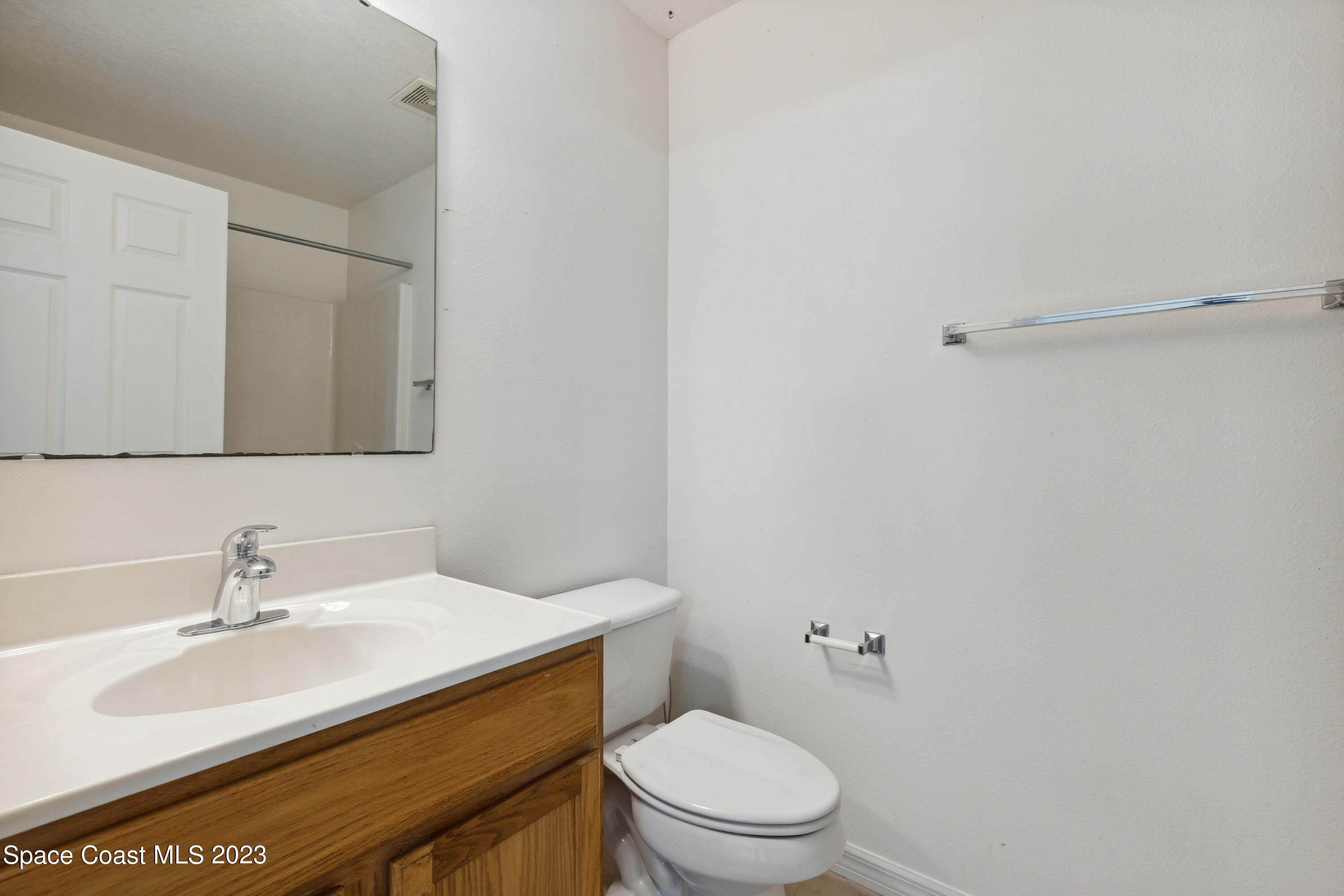 4625 Elena Way Melbourne, FL 32934 - Photo 15 of 26 a bathroom with a sink mirror vanity and toilet
