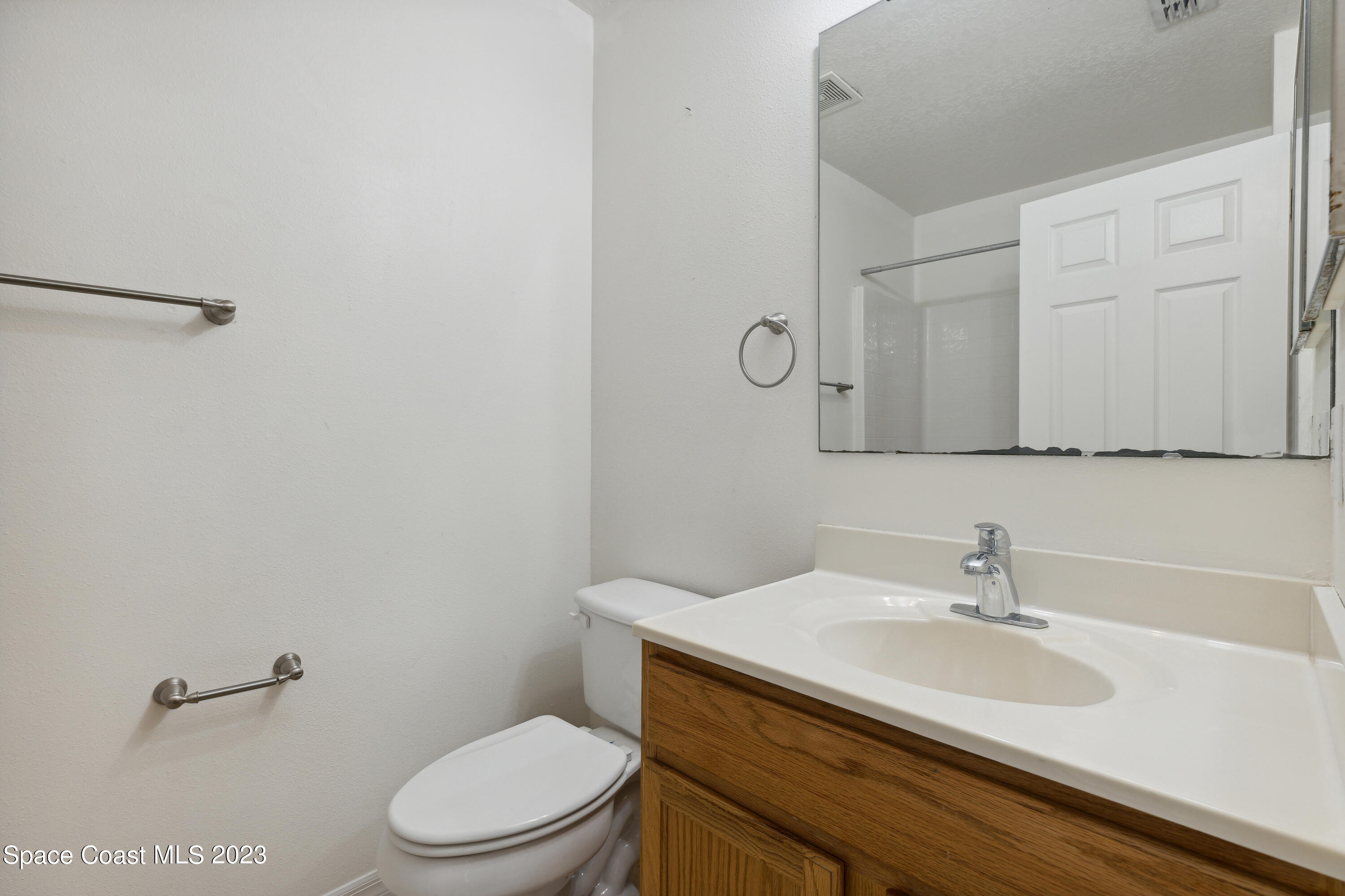 4625 Elena Way Melbourne, FL 32934 - Photo 18 of 26 a bathroom with a sink a toilet and a mirror