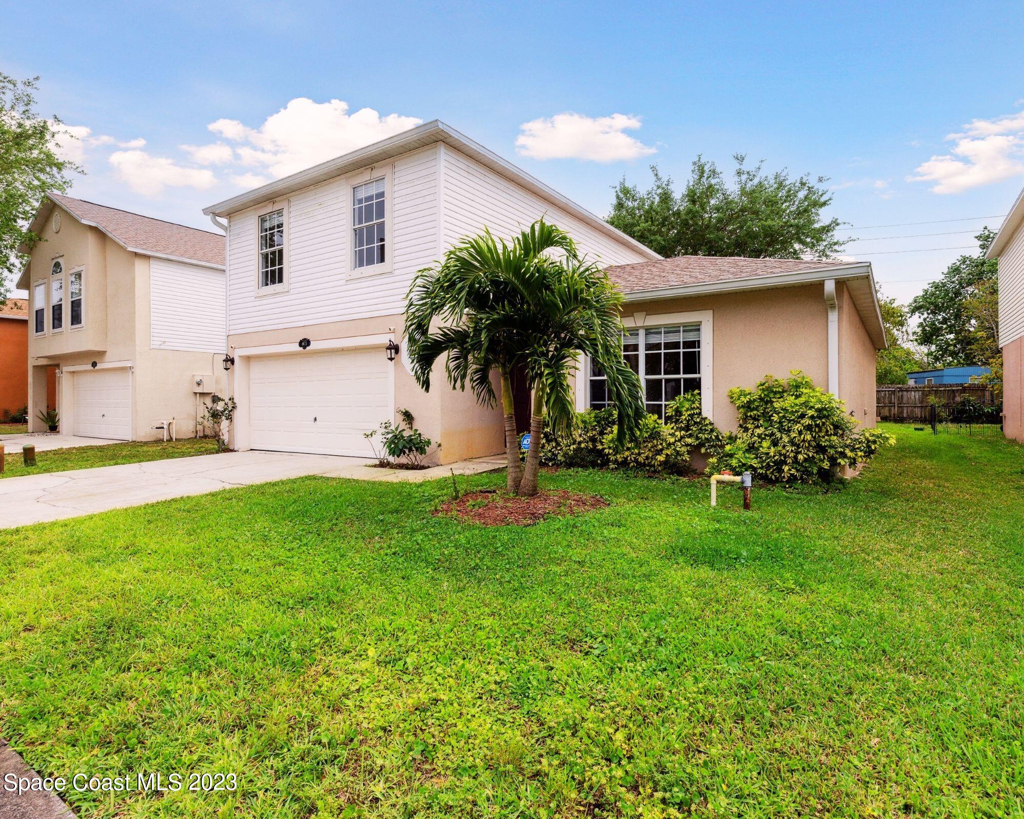 4625 Elena Way Melbourne, FL 32934 - Photo 2 of 26 a front view of house with yard and green space