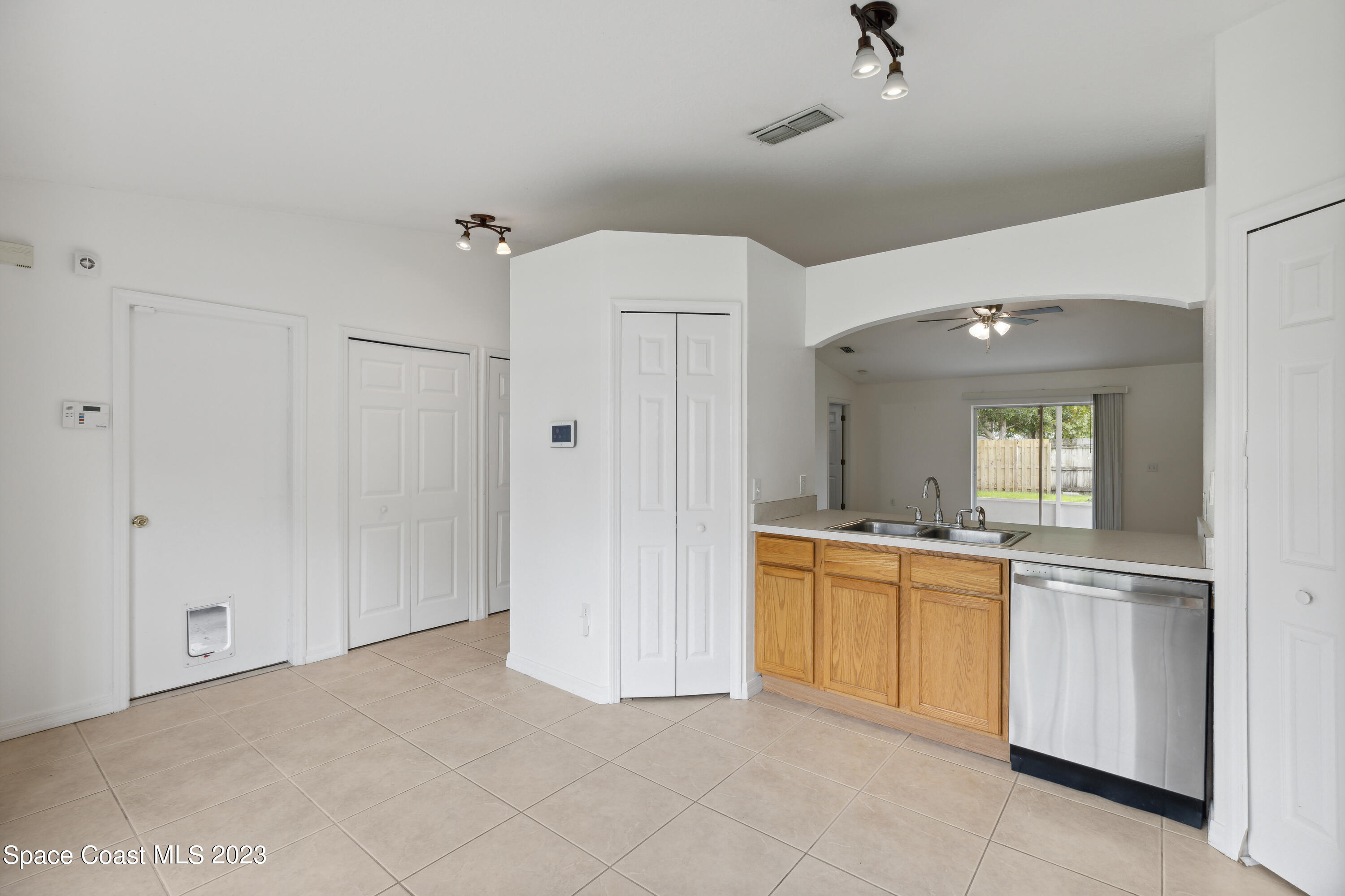 4625 Elena Way Melbourne, FL 32934 - Photo 5 of 26 a view of a kitchen with a sink and dishwasher a refrigerator with white cabinets