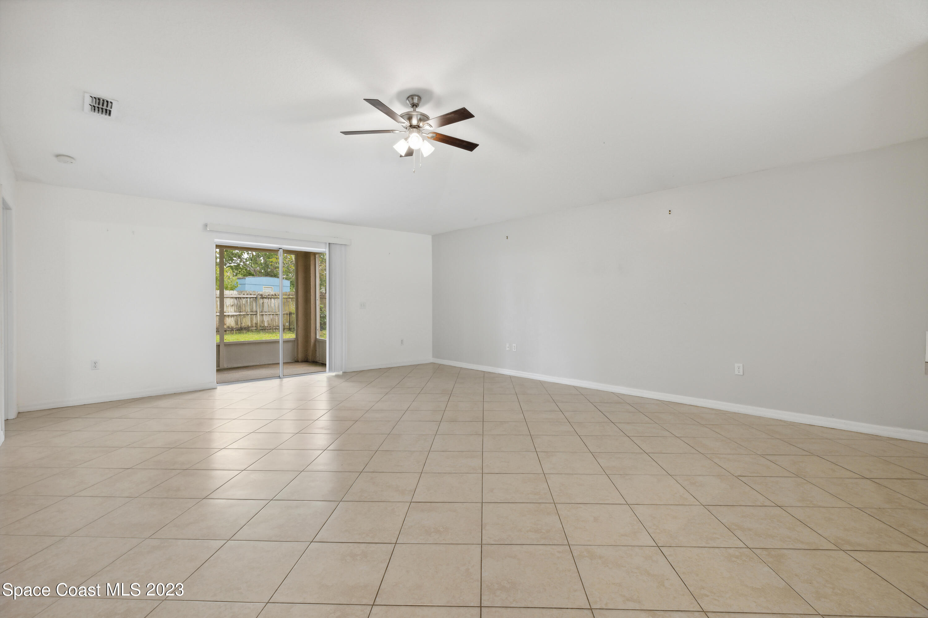 4625 Elena Way Melbourne, FL 32934 - Photo 7 of 26 a view of an empty room with chandelier fan