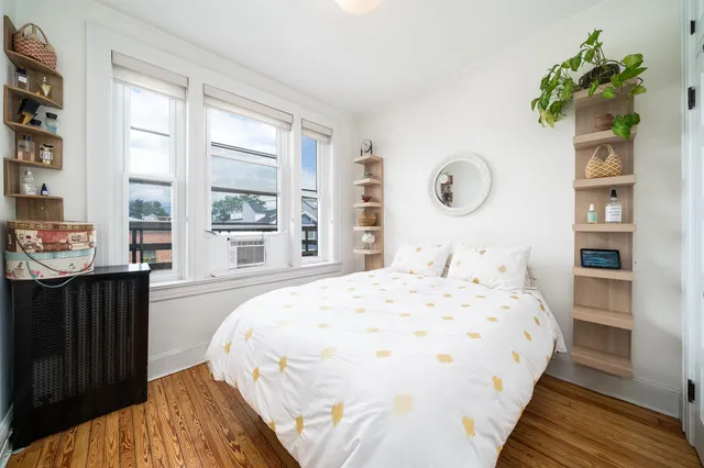 a bedroom with a bed and a large window
