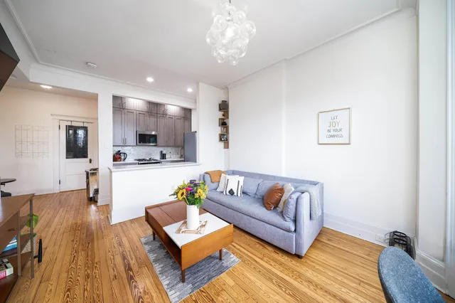 a living room with furniture and kitchen view