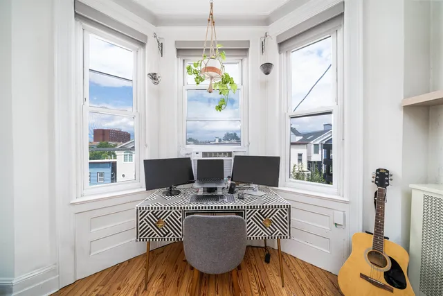 a view of a dining room with furniture a chandelier and wooden floor